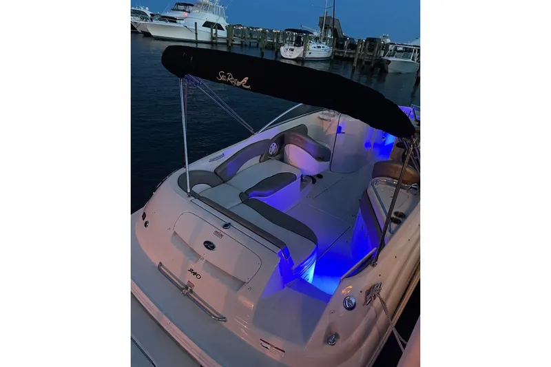 Slide: The Image of 2006 Sea Ray 240 Sundeck boat with blue interior lighting at a marina. - 4
