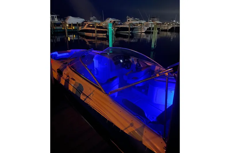 Slide: The Image of 2006 Sea Ray 240 Sundeck with blue interior lights docked at night. - 5