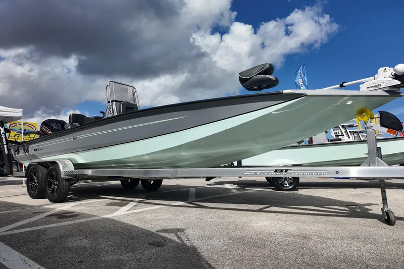 The Image of 2026 Xpress H24B Bay boat on trailer under cloudy sky. - 0