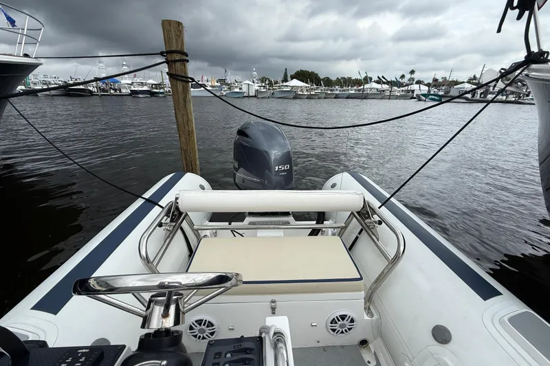 Slide: The Image of 2024 Novurania Catamaran 20 docked, featuring a 150 horsepower outboard motor. - 13