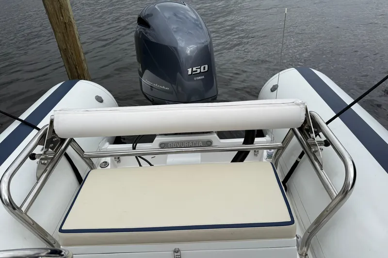 Slide: The Image of 2024 Novurania Catamaran 20 with Yamaha 150 engine, docked on calm water. - 14