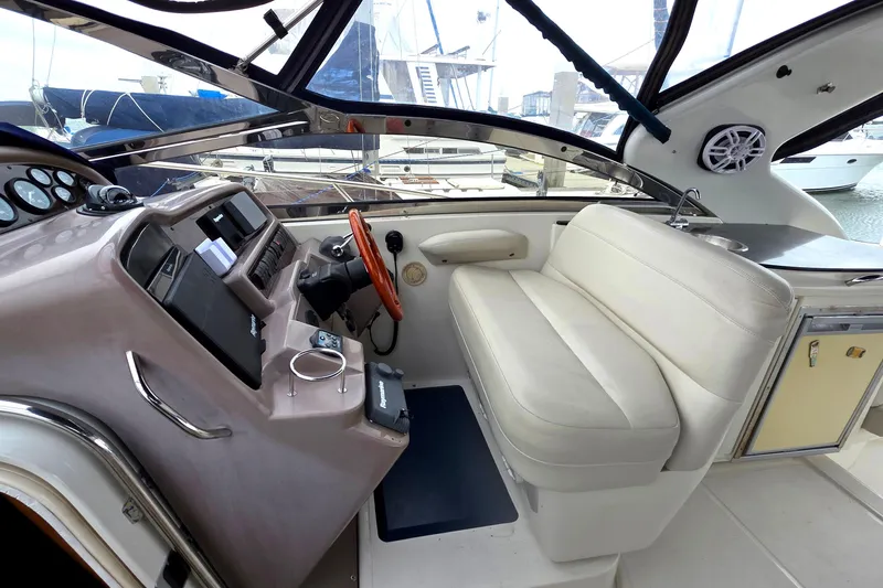 Slide: The Image of 2002 Regal Commodore 4260 yacht cockpit with steering wheel and seating area. - 12