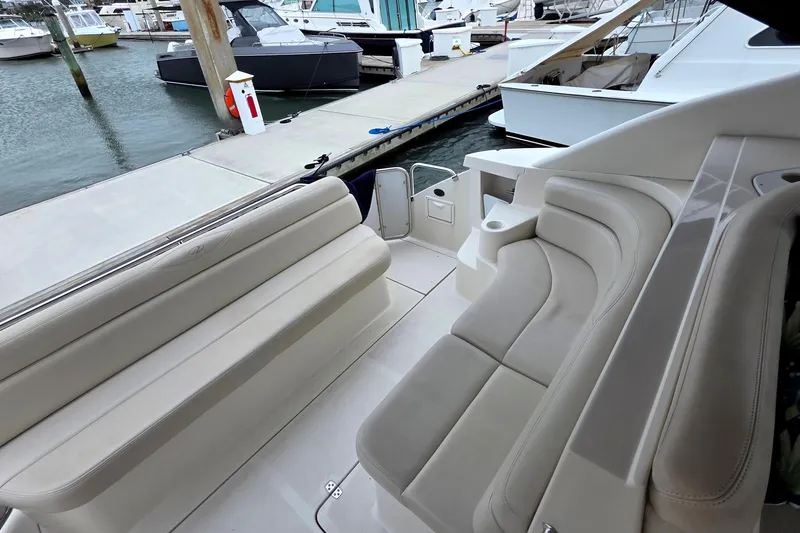 Slide: The Image of 2002 Regal Commodore 4260 boat interior with beige seating at a marina. - 14