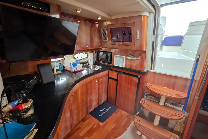 Slide: The Image of Luxurious 2002 Regal Commodore 4260 yacht interior with modern kitchen and wooden accents. - 18
