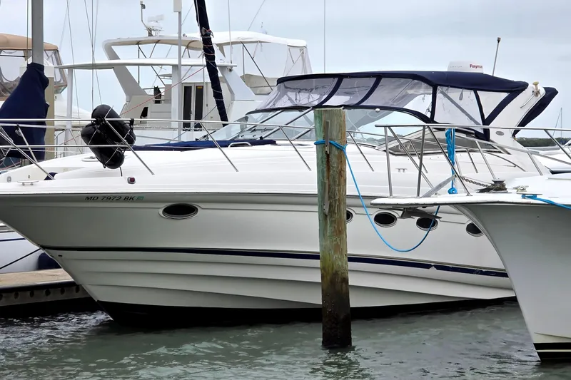 Slide: The Image of 2002 Regal Commodore 4260 yacht docked at marina, featuring sleek design and white exterior. - 2