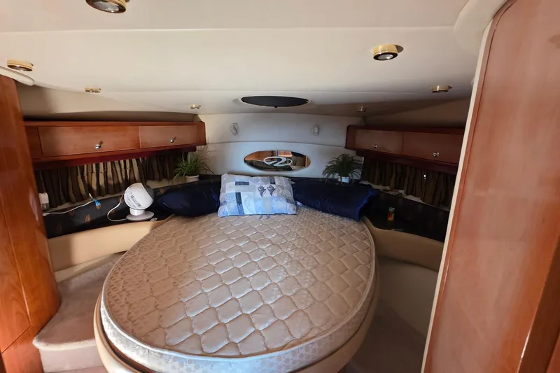 Slide: The Image of Luxurious cabin interior of 2002 Regal Commodore 4260 yacht with cozy bed and wooden accents. - 23