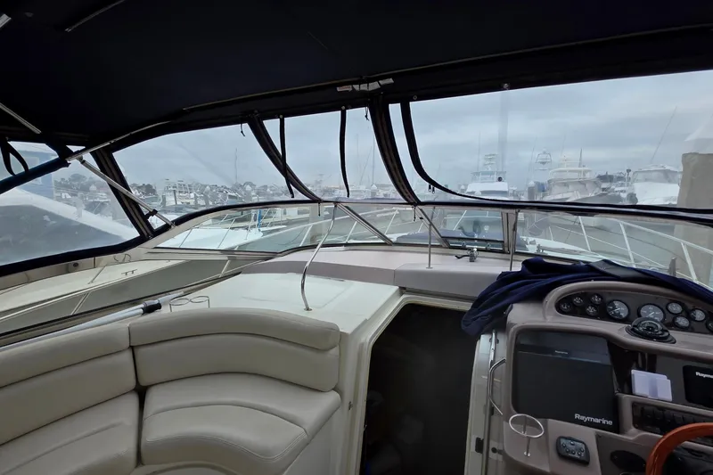 Slide: The Image of 2002 Regal Commodore 4260 yacht interior with helm, seating, and marina view. - 27