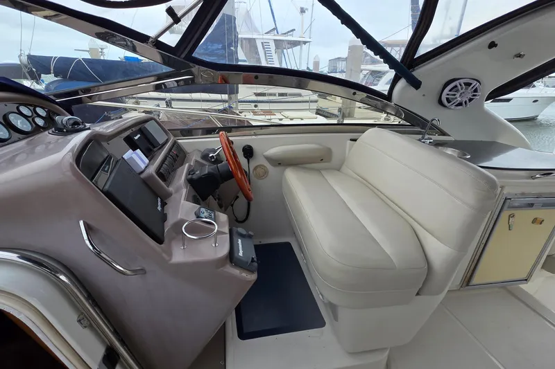 Slide: The Image of 2002 Regal Commodore 4260 yacht interior with helm, seating, and marina view. - 31