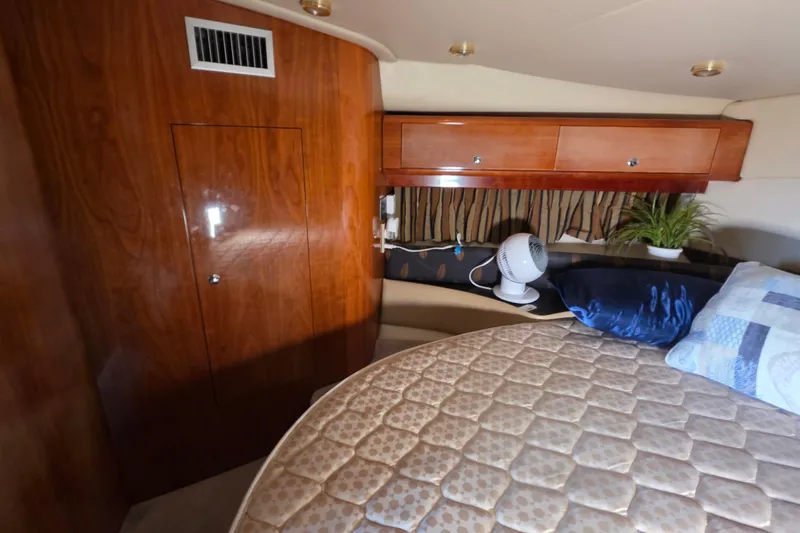 Slide: The Image of Interior cabin of 2002 Regal Commodore 4260 yacht with wood paneling and cozy bedding. - 40