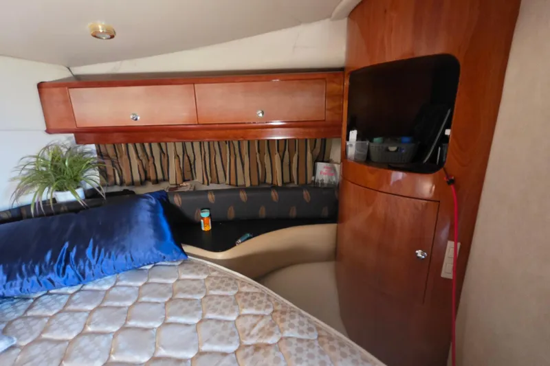 Slide: The Image of Interior of 2002 Regal Commodore 4260 yacht with wooden cabinets and cozy bedding. - 42