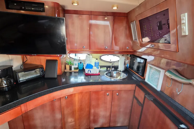 Slide: The Image of Luxurious 2002 Regal Commodore 4260 yacht kitchen with modern appliances and wood cabinetry. - 44