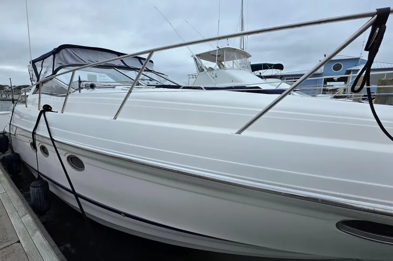 Slide: The Image of 2002 Regal Commodore 4260 yacht docked at marina under cloudy sky. - 5