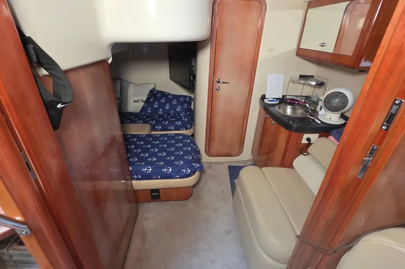 Slide: The Image of 2002 Regal Commodore 4260 cabin interior with cozy beds and compact kitchenette. - 54