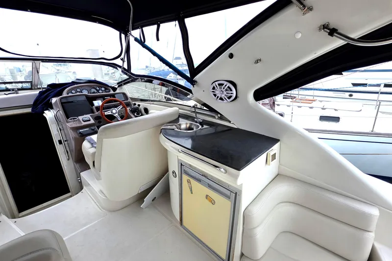 Slide: The Image of Interior of 2002 Regal Commodore 4260 yacht with helm, seating, and kitchenette. - 7