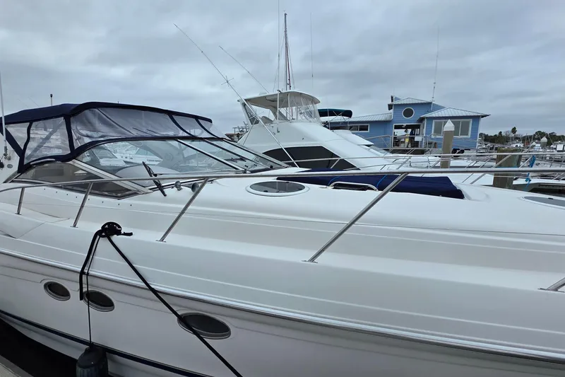 Slide: The Image of 2002 Regal Commodore 4260 yacht docked at marina under cloudy skies. - 8