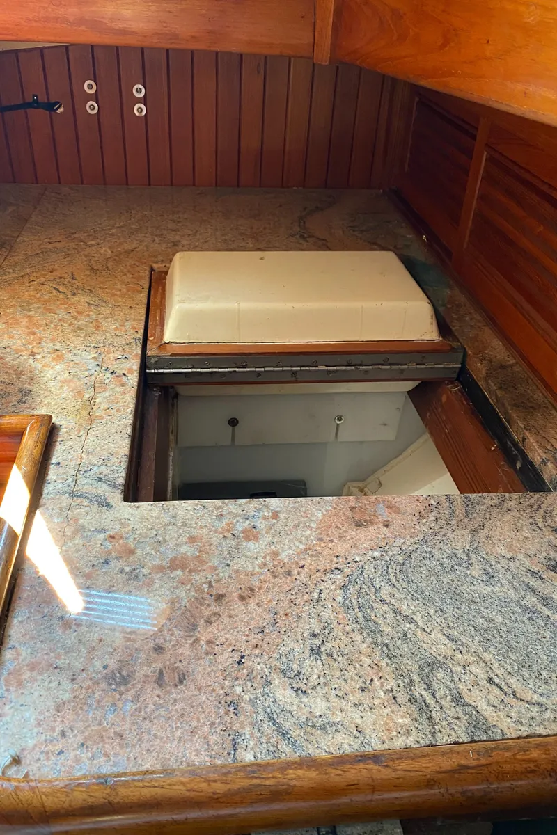 Slide: The Image of 1981 Hans Christian 38 Mark II yacht interior with granite countertop and storage compartment. - 11