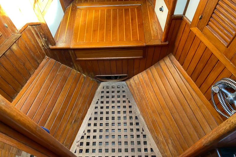Slide: The Image of Wooden interior of 1981 Hans Christian 38 Mark II sailboat, featuring teak paneling and lattice flooring. - 21