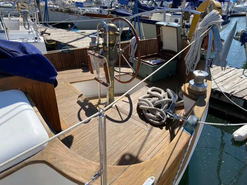 Slide: The Image of 1981 Hans Christian 38 Mark II sailboat with wooden deck and steering wheel at marina. - 28