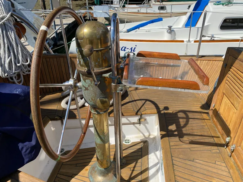 Slide: The Image of Steering wheel of 1981 Hans Christian 38 Mark II sailboat, featuring wooden and brass elements. - 30