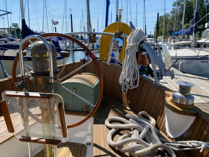 Slide: The Image of Cockpit of 1981 Hans Christian 38 Mark II sailboat with wooden wheel and ropes. - 32