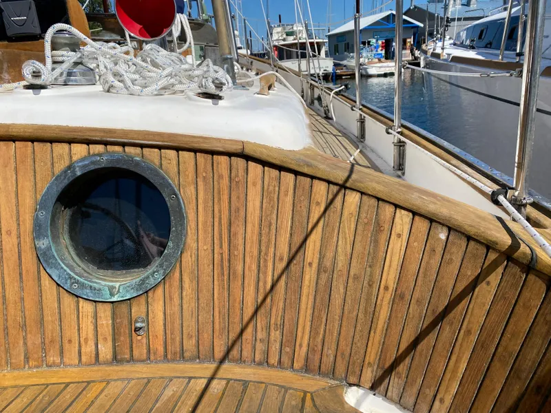 Slide: The Image of 1981 Hans Christian 38 Mark II sailboat deck with wooden paneling and porthole. - 33