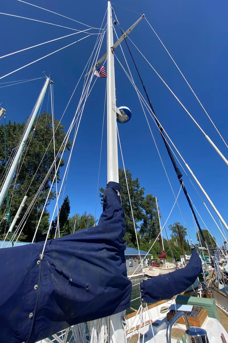 Slide: The Image of 1981 Hans Christian 38 Mark II sailboat with blue sail in harbor. - 47