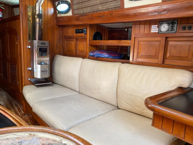 Slide: The Image of Interior of 1981 Hans Christian 38 Mark II sailboat with wooden paneling and beige sofa. - 5