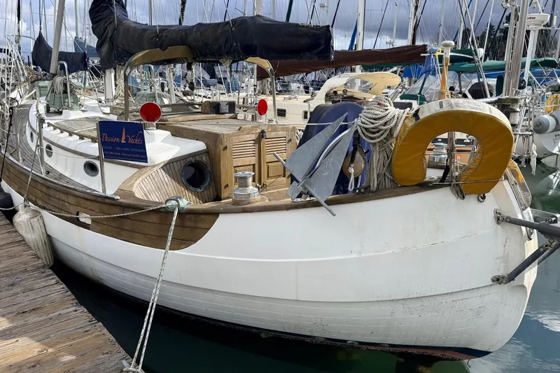 Slide: The Image of 1981 Hans Christian 38 Mark II sailboat docked, featuring wooden deck and nautical equipment. - 69