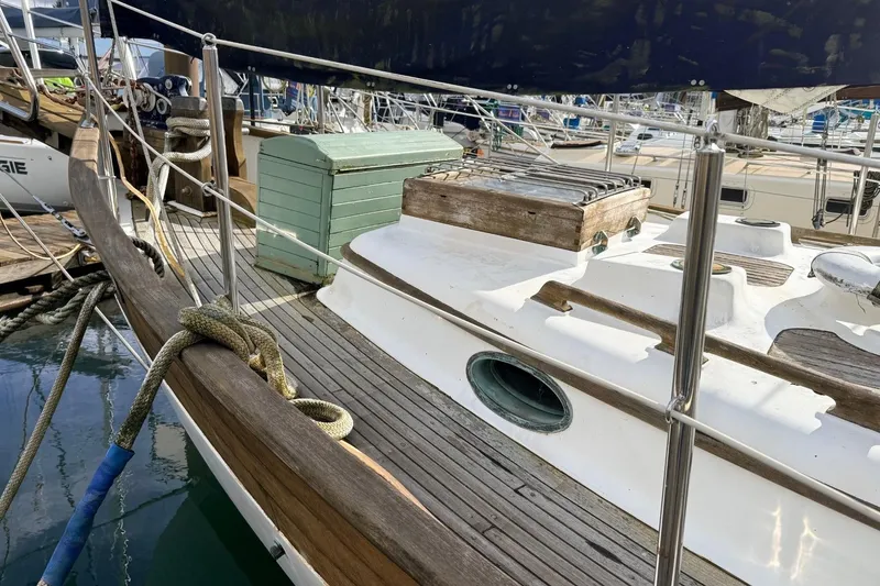 Slide: The Image of 1981 Hans Christian 38 Mark II sailboat deck with wooden details and docked ropes. - 71