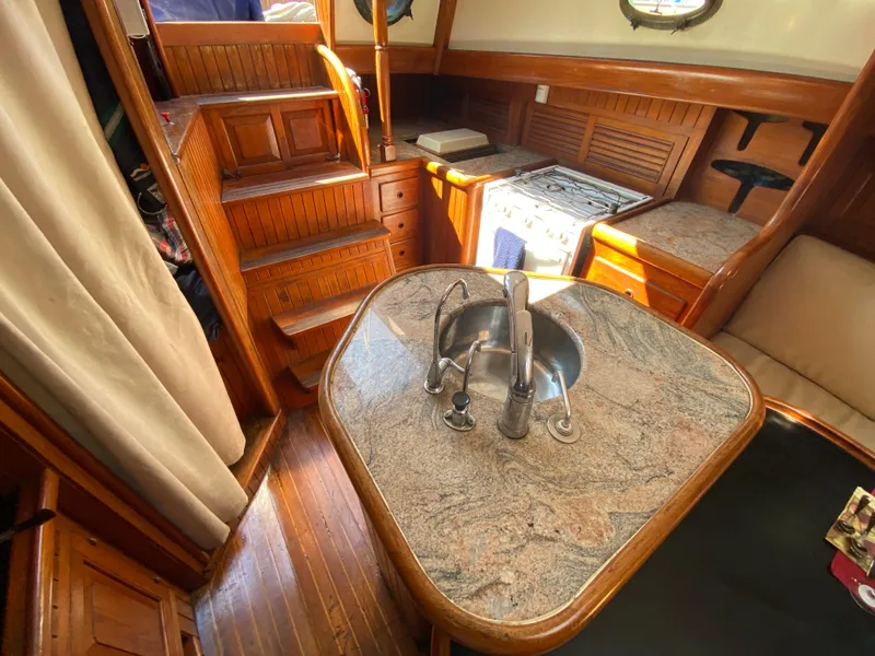 Slide: The Image of 1981 Hans Christian 38 Mark II yacht interior with wooden cabinetry and granite countertop. - 8