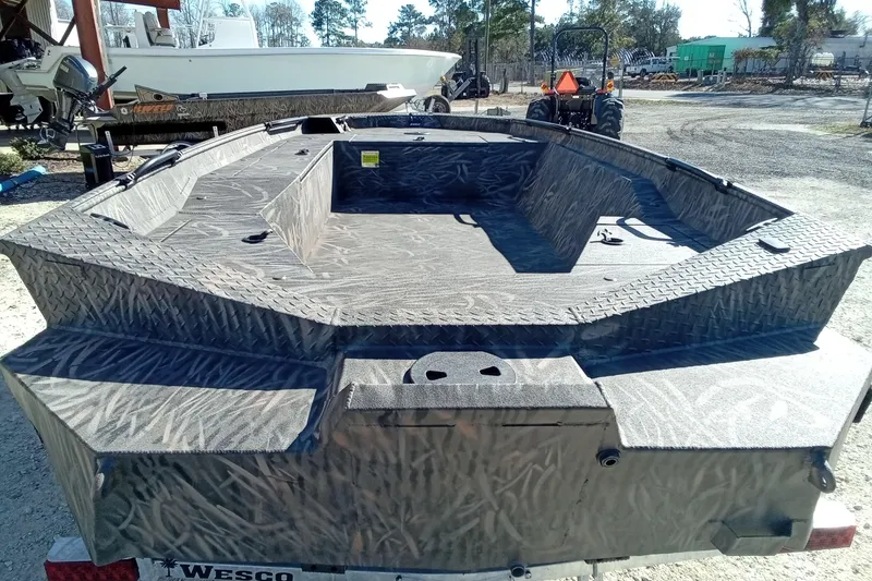 Slide: The Image of 2026 Alweld 1756 Invader boat with camouflage design, parked outdoors. - 12