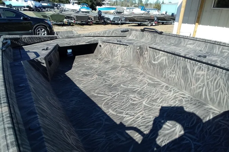 Slide: The Image of 2026 Alweld 1756 Invader boat interior with camouflage pattern, parked outdoors. - 7