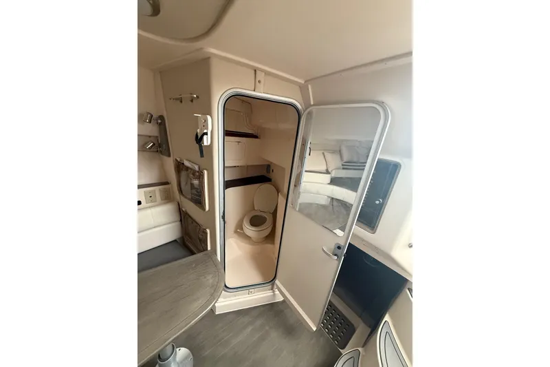 Slide: The Image of 2005 Grady-White Express 330 cabin interior with bathroom and seating area. - 18
