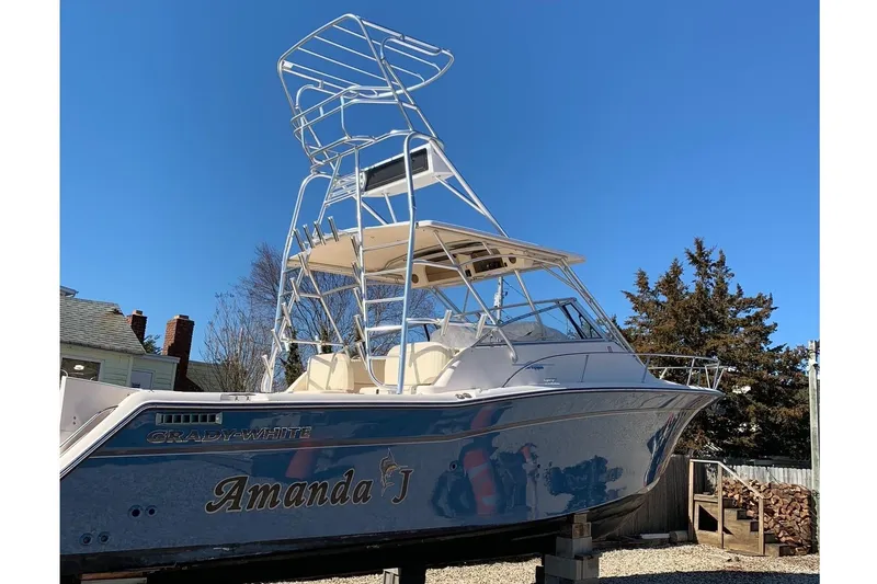 Slide: The Image of 2005 Grady-White Express 330 boat with tower, named "Amanda J," under clear blue sky. - 2