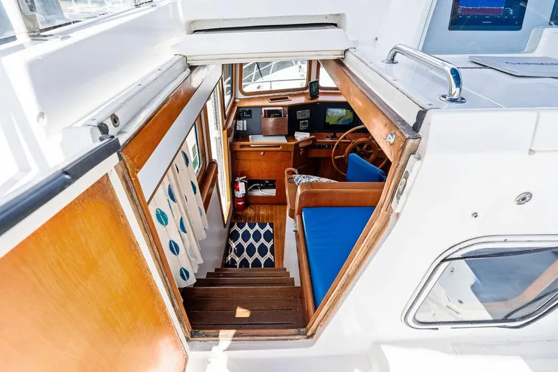Slide: The Image of Interior view of 2000 Selene Solo boat, featuring wooden stairs and blue seating. - 14