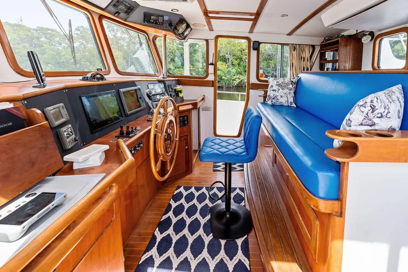 Slide: The Image of Interior of 2000 Selene Solo boat with blue seating, wooden helm, and navigation equipment. - 16