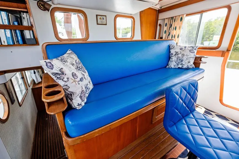 Slide: The Image of Cozy interior of 2000 Selene Solo boat with blue seating and decorative pillows. - 17