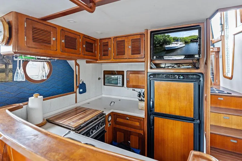 Slide: The Image of Interior of 2000 Selene Solo yacht kitchen with wooden cabinets and modern appliances. - 22