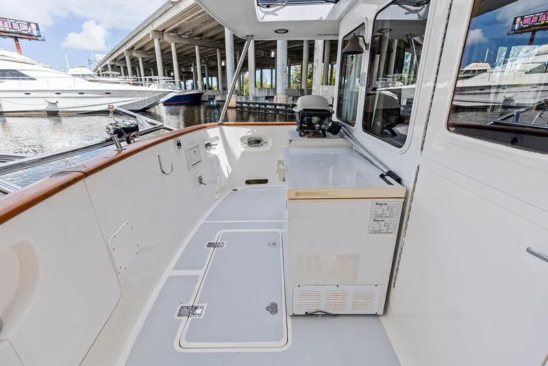 Slide: The Image of Selene Solo 2000 yacht deck with white interior, docked near other boats. - 24