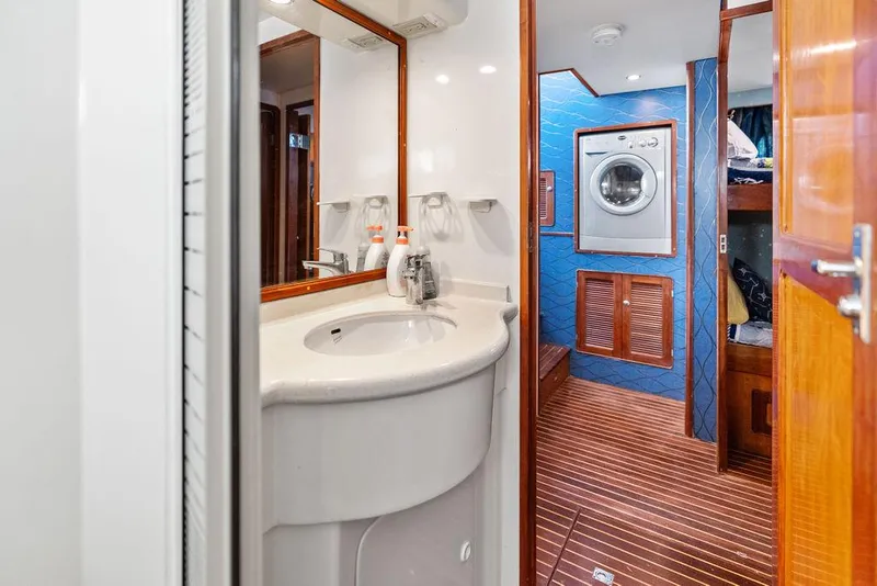 Slide: The Image of Bathroom and laundry area inside a 2000 Selene Solo yacht, featuring a sink and washing machine. - 29