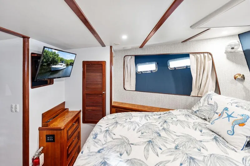 Slide: The Image of Cozy bedroom in 2000 Selene Solo yacht with TV, wooden accents, and nautical-themed bedding. - 31