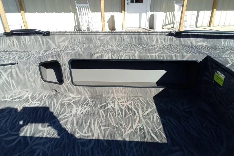 Slide: The Image of 2026 Alweld 1652 Invader boat interior with camouflage pattern and storage compartments. - 8
