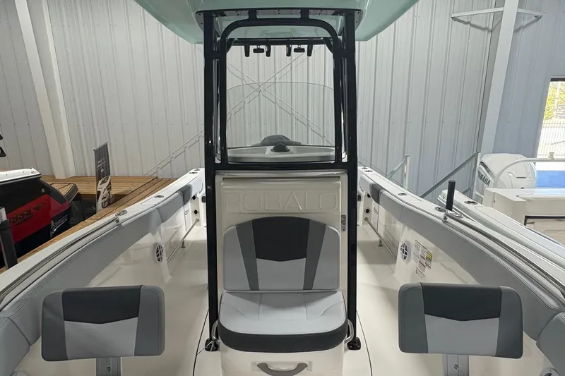 Slide: The Image of 2025 Robalo R232 Explorer boat interior with seating and console in showroom. - 11