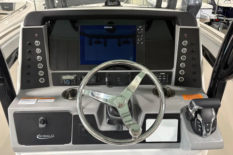 Slide: The Image of 2025 Robalo R232 Explorer boat dashboard with steering wheel and control panel. - 8