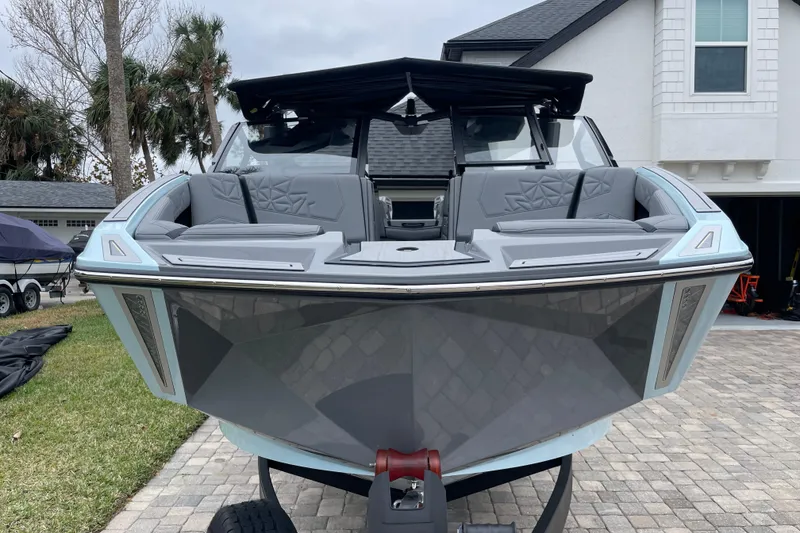 Slide: The Image of 2025 Nautique Super Air Nautique G23 Paragon boat on driveway, showcasing sleek design. - 1