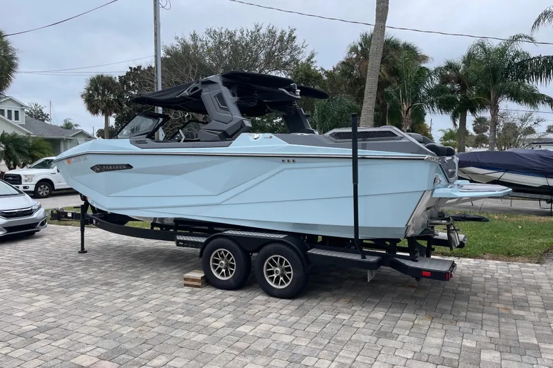 Slide: The Image of 2025 Nautique Super Air Nautique G23 Paragon boat on trailer, parked in driveway. - 4