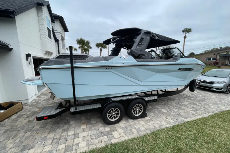 Slide: The Image of 2025 Nautique Super Air Nautique G23 Paragon boat on trailer in driveway. - 7