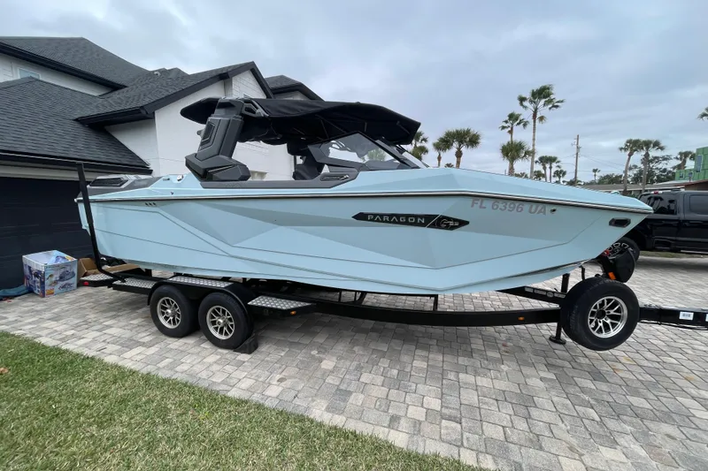 Slide: The Image of 2025 Nautique Super Air Nautique G23 Paragon boat on trailer, parked in driveway. - 8