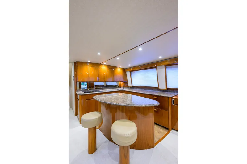 Slide: The Image of 2015 Viking 62 Convertible yacht cabin with bed, TV, and tropical pillow. - 28