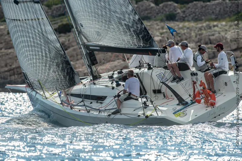 Slide: The Image of Italia Yachts 9.98 sailing with crew, 2026 model, on sparkling blue water. - 2